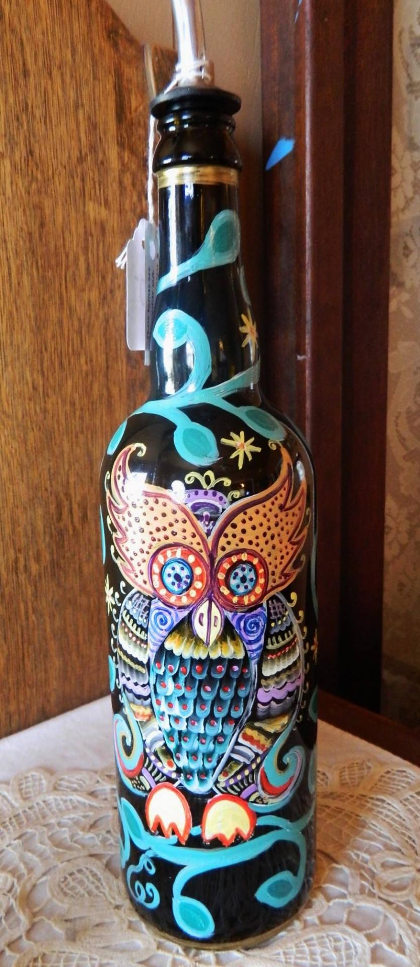 Hand-painted recycled bottle featuring a colorful owl with teal vines